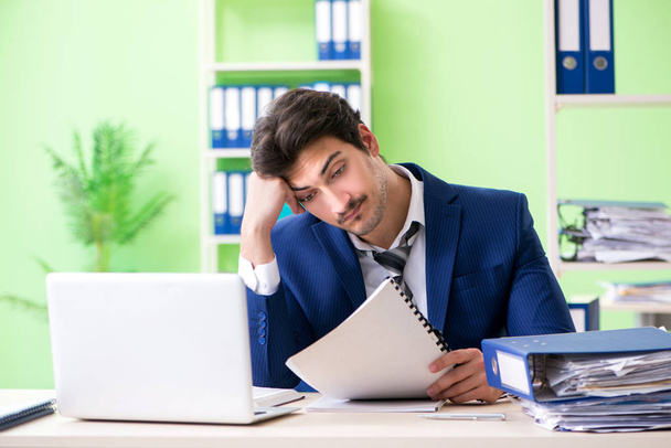 Businessman unhappy with excessive work sitting in the office  - Photo, Image