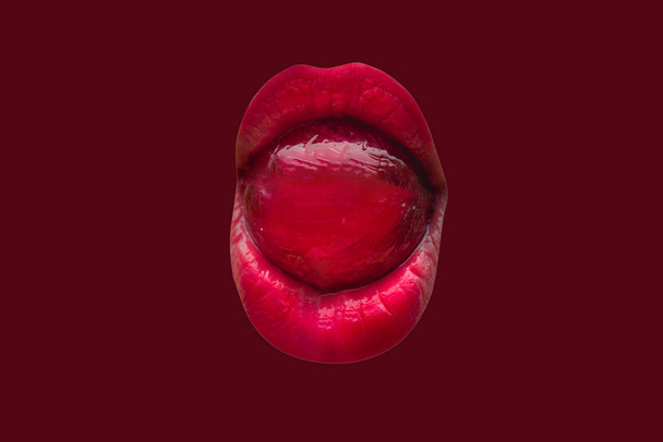 Red concept. Sweets in the female mouth. Beautiful lipstick and cosmetics. Sweet life. Lollipop on the tongue. Damage sugar for teeth. Female mouth close-up isolated on red background. Young lips icon - Foto, Bild