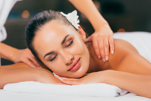 attractive young woman having massage and relaxing at massage salon  - Φωτογραφία, εικόνα