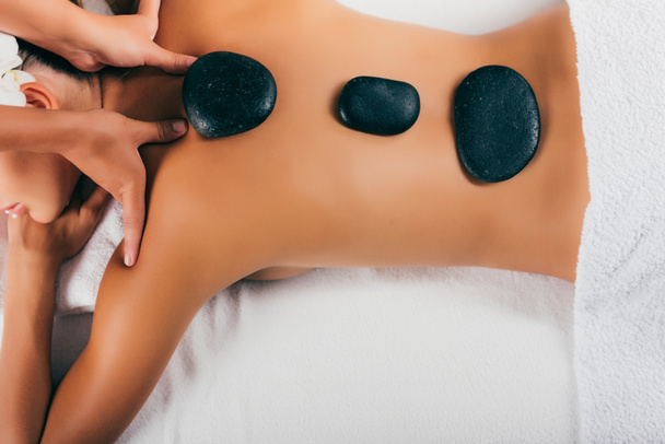 jeune femme ayant la thérapie de pierre au salon de massage
  - Photo, image