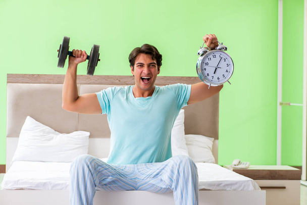 Jeune homme en pyjama faisant des exercices matinaux  - Photo, image