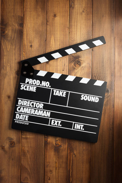 movie clapper board at wooden background texture, top view - Fotó, kép