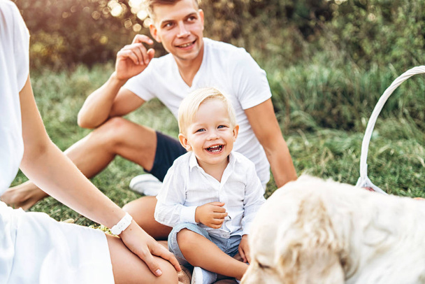 Young pretty family on picnic with dog - Foto, Bild