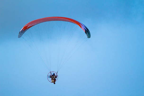 Un hombre vuela en un parapente en el cielo
 - Foto, Imagen