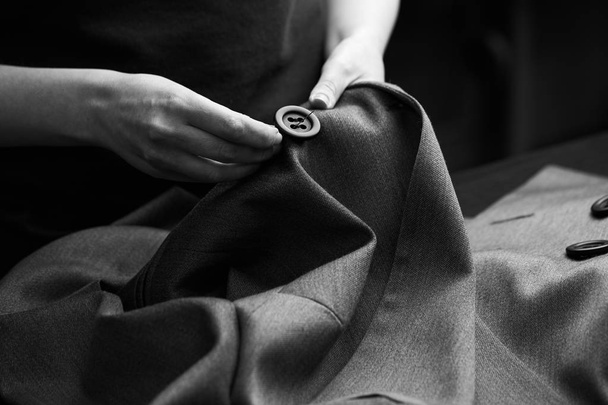 Coser los botones de la chaqueta. atelier a medida - confección y reparación de ropa exclusiva hecha a mano, negocio privado, concepto de ocupación creativa
 - Foto, imagen