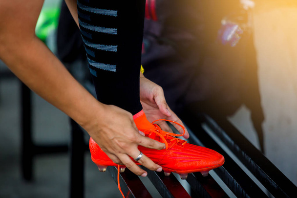 Soccer players stand and tying sport shoelaces before training football. - Photo, Image