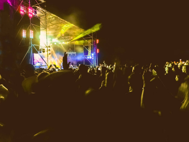 Вечеринка, концерт. Толпа поднимает руки и наслаждается великим рок-фестивалем. blur bokeh для фона
. - Фото, изображение