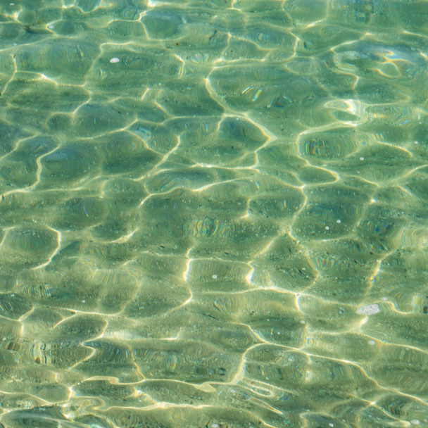 Interplay of light in turquoise oceanic water as background, sunny day, transparent water - Photo, Image