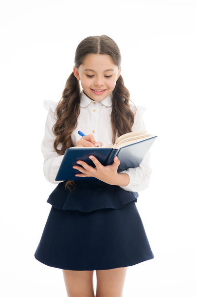 Schoolgirl write daily schedule notepad isolated on white. Little child hold textbook with pen. Plan for week. Home schooling education. Adorable bookworm planning her studying schedule for week - Photo, image