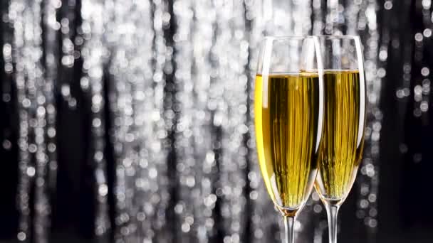 Close-up van twee champagneglazen over vakantie klatergoud bokeh knipperende achtergrond. - Video