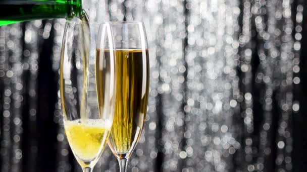 zwei Gläser Champagner und eine Flasche Champagner mit weihnachtlicher Lametta-Dekoration. - Filmmaterial, Video