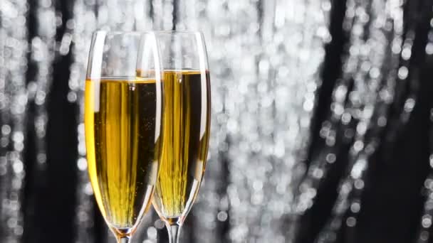 Detailní záběr dvou sklenic na šampaňské nad dovolenou pozlátko bokeh blikající pozadí. - Záběry, video
