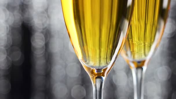 Close up de dois copos de champanhe com prata brilho ouropel decoração de Natal no fundo
. - Filmagem, Vídeo