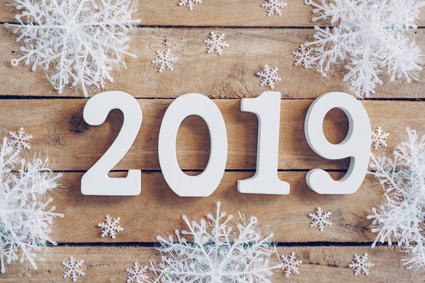 Neujahr 2019 auf hölzernem braunem Weihnachtshintergrund mit Schneeflocken und Weihnachtsdekoration. - Foto, Bild