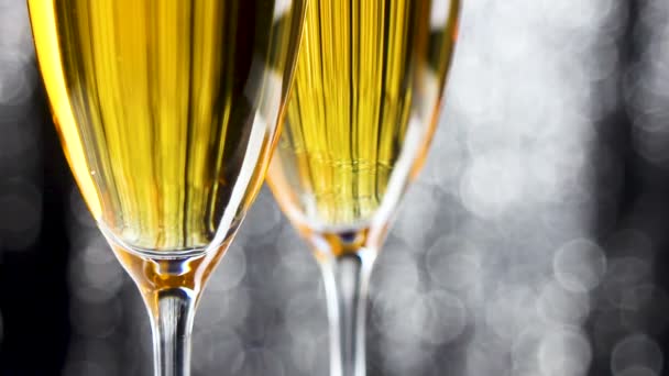 Detailní záběr dvou sklenic na šampaňské s stříbrné třpytky pozlátko vánoční dekorace na pozadí. - Záběry, video