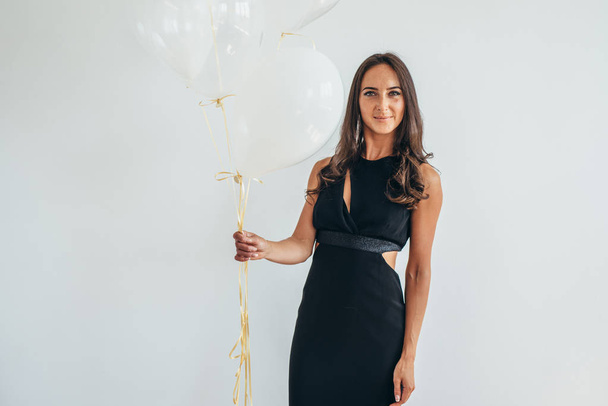 Cheerful young woman with balloons standing and smiling - Fotografie, Obrázek