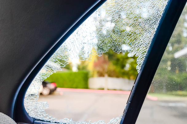 Outside close-up view broken passenger window car smashed by thief or accident. Damaged glass from car theft. Motor Vehicle Insurance Claim Themed concept background. - Foto, Imagem