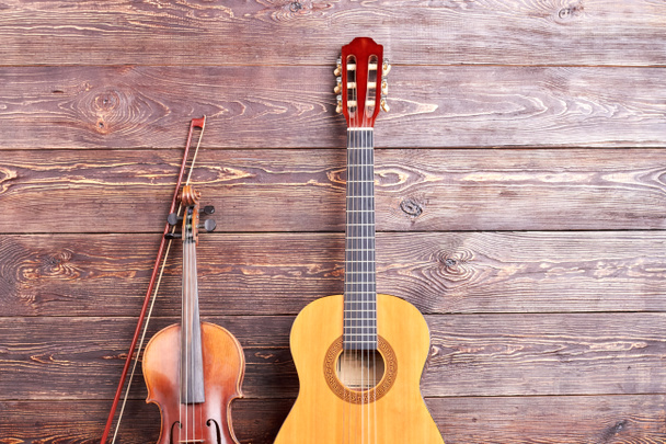 Gitara akustyczna i skrzypce na podłoże drewniane. - Zdjęcie, obraz