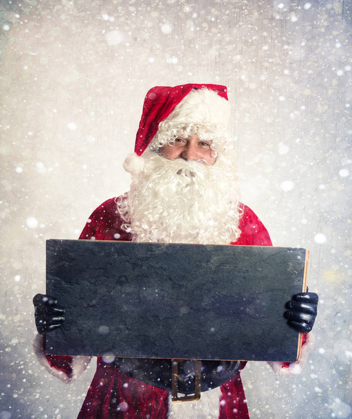 Weihnachtsmann mit Kreidetafel und leerer Kreidetafel in den Händen  - Foto, Bild