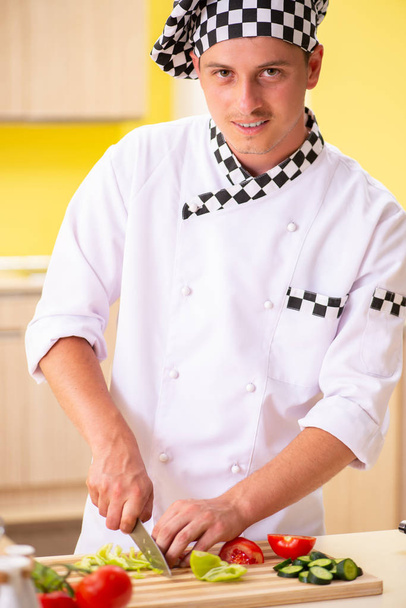 Young professional cook preparing salad at kitchen - Foto, imagen