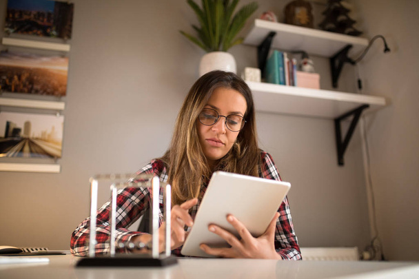 Beautiful woman using a tablet while doing a research.  - 写真・画像