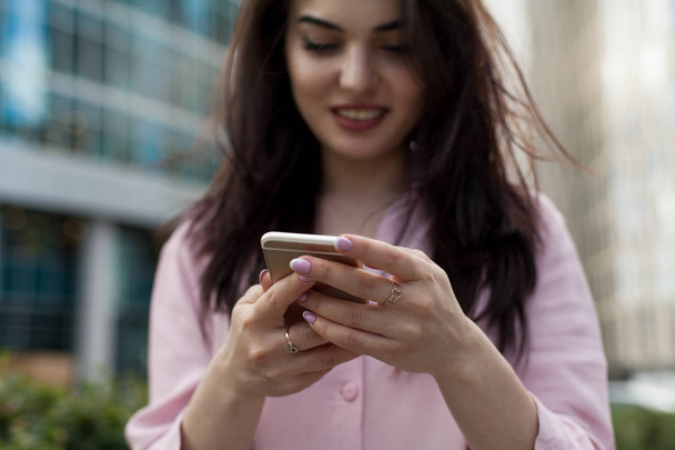 Cropped shot of young girl using modern smartphone device, female hands holding mobile phone on city street, smiling successful female entrepreneur using cellphone wireless connection for work outside - Fotoğraf, Görsel