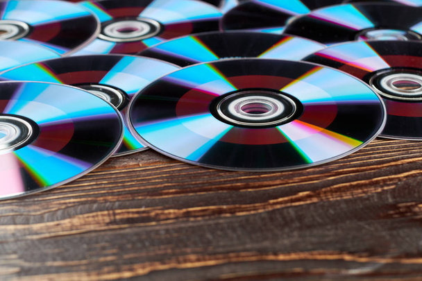 Деревянный фон с большим количеством компакт-дисков
. - Фото, изображение
