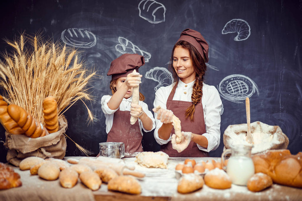 Woman and girl making pastries together - Foto, Bild