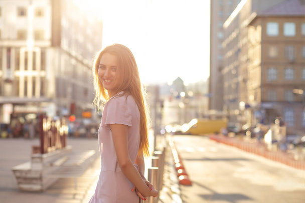 Modelo rubia feliz posando en la calle en un rayo de sol. Concepto de calle. Espacio vacío
 - Foto, imagen
