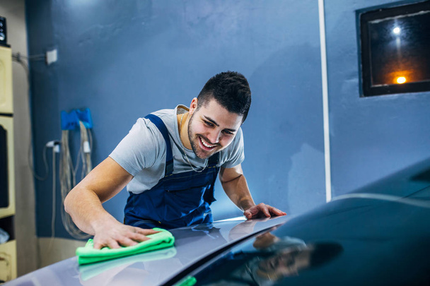 Man washing his car in a workshop. - Zdjęcie, obraz