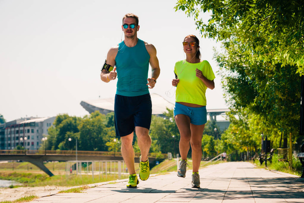 Fitness sport couple running jogging outside - Foto, afbeelding