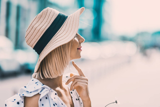 Portre güzel poz ve sokak yaşam tarzı üzerinde gülümseyen güneşli günde dolgun dudaklar ile modern şapkalı'deki genç sarışın kız  - Fotoğraf, Görsel