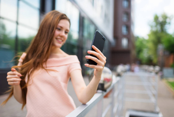 Adolescente sonriendo mientras toma una foto de selfie
 - Foto, imagen