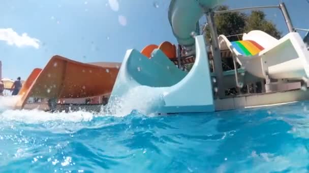 Aquapark, parlak güneşli bir günde üç renkli su kaydırağı ağır çekim görüntüleri - Video, Çekim