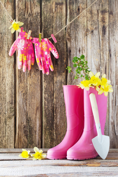 rubber boots and spring flowers on wooden background - Фото, зображення