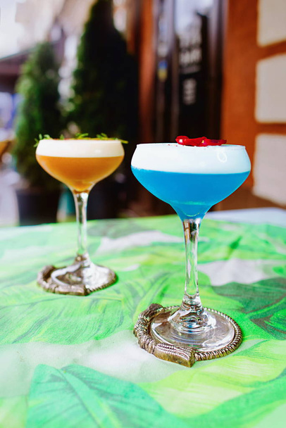 Blauer Curaçao und beige Cocktails auf dem Tisch im Freien - Foto, Bild