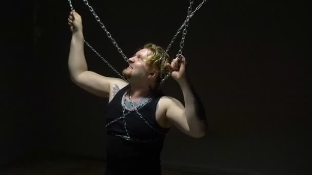 Torturowany blond człowiek w łańcuchach - Materiał filmowy, wideo