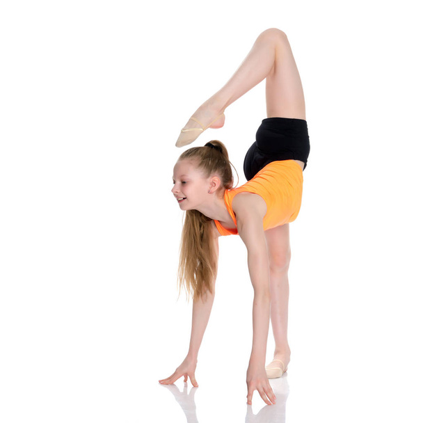 The gymnast perform an acrobatic element on the floor. - Φωτογραφία, εικόνα
