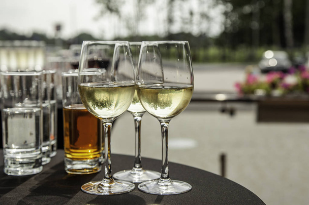 Очки с белым вином на шведском столе
 - Фото, изображение