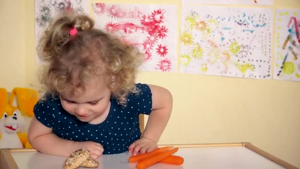 niedliche kleine Mädchen entscheiden, Karotten statt Honigkuchen zu essen - Filmmaterial, Video