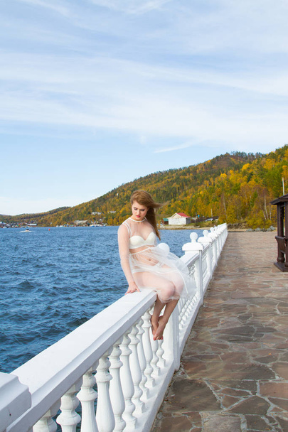 Menina em lingerie e vestido transparente na costa do Lago Baikal
 - Foto, Imagem