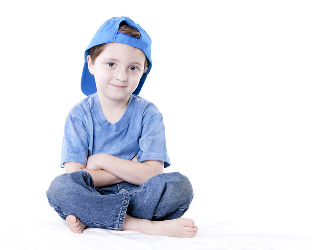 Smiling caucasian little boy sitting cross legged with his arms crossed - Φωτογραφία, εικόνα