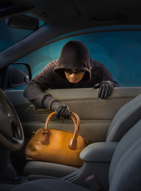 κλέφτης κλέβει γυναικεία τσάντα από αυτοκίνητο - Φωτογραφία, εικόνα