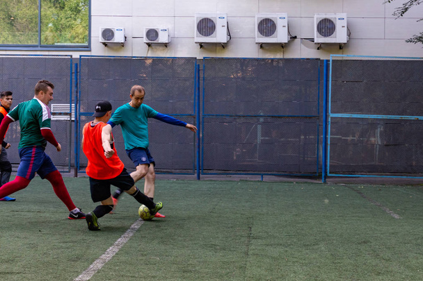 los hombres juegan mini fútbol en el césped artificial verde
 - Foto, Imagen