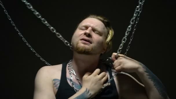 Crazy blond man bound in chains - Footage, Video