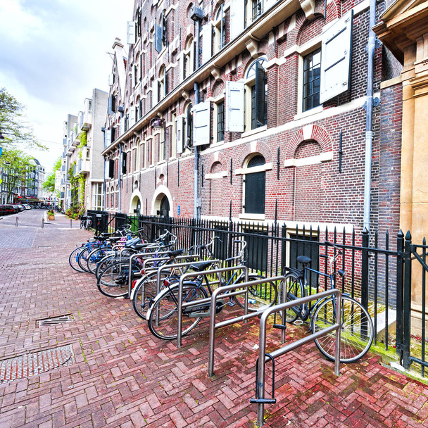 Typické holandské cihlové domy v Holandsku. Street View s kola parkujeme v historickém centru Amsterdamu v Nizozemsku - Fotografie, Obrázek