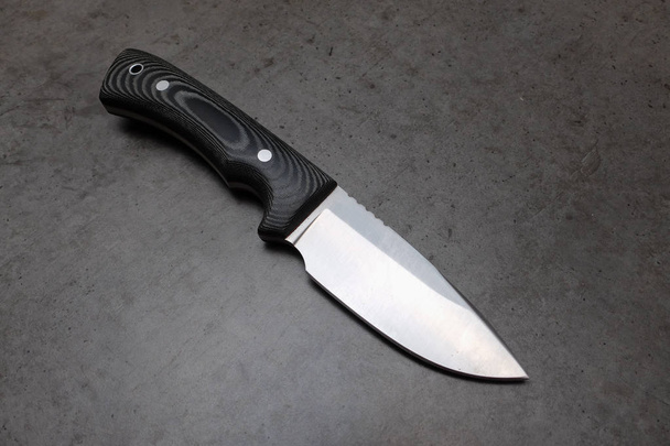 Hunting knife on a dark gray table - Photo, Image