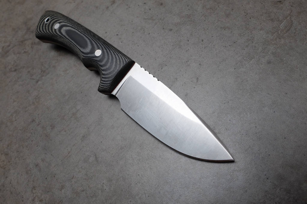 Hunting knife on a dark gray table - Photo, Image