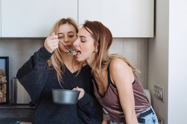 two girls eat porridge at home - Foto, afbeelding