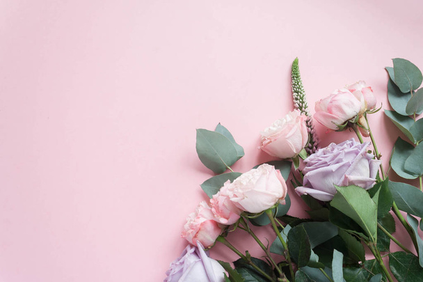Frame van de paarse en roze rozen, witte Lisianthus en verschillende bloemen op roze achtergrond. Plat lag, top uitzicht - Foto, afbeelding